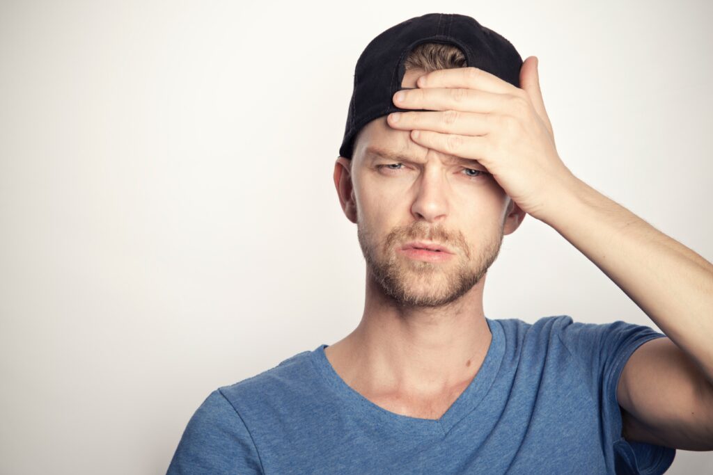 man  with blue shirt suffers from headache